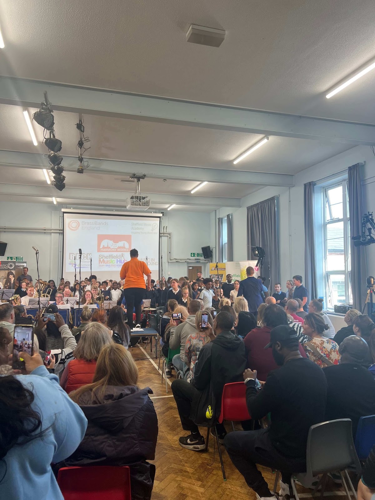 Helen Minshall from BBE leads Sheffield children in a marching song at a school performance.
