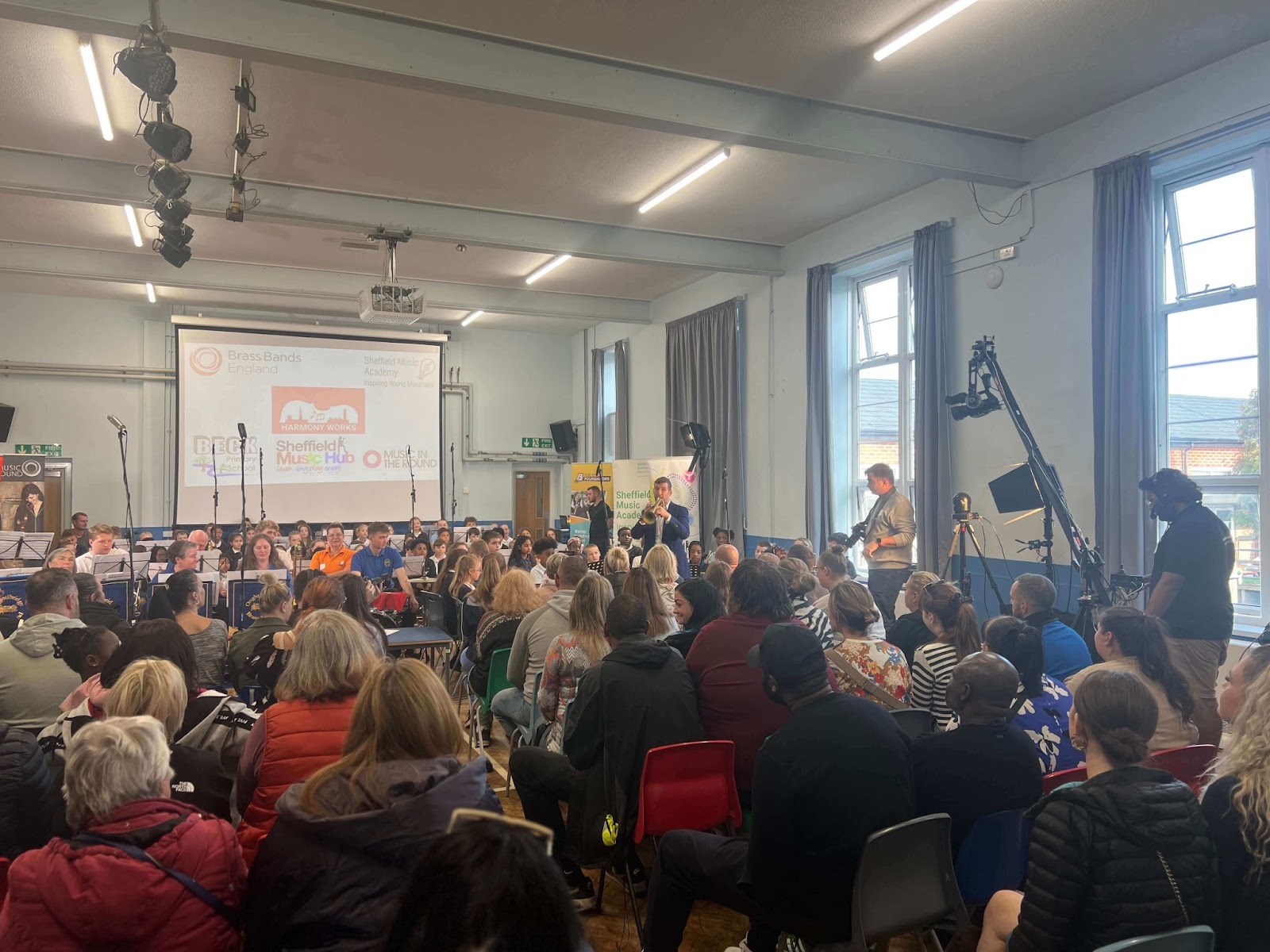 Sheffield Music Hub Brass Music Leader Andy Harris plays a trumpet solo with children at Beck Primary, Shiregreen in Sheffield, as proud parents watch on.