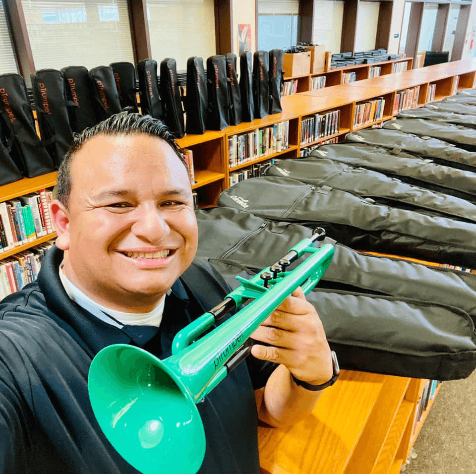 Educator Ramón Rivera holding a green pTrumpet.